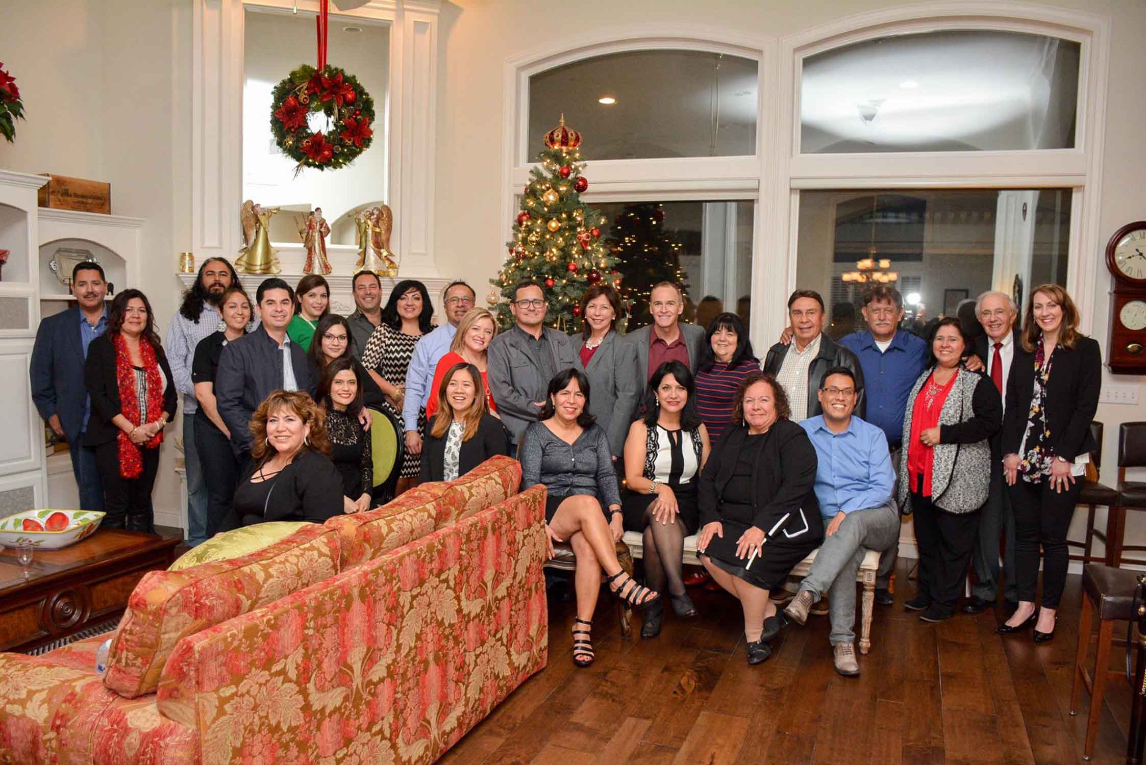 Members of La Raza Law posing in front of a Christmas tree.
