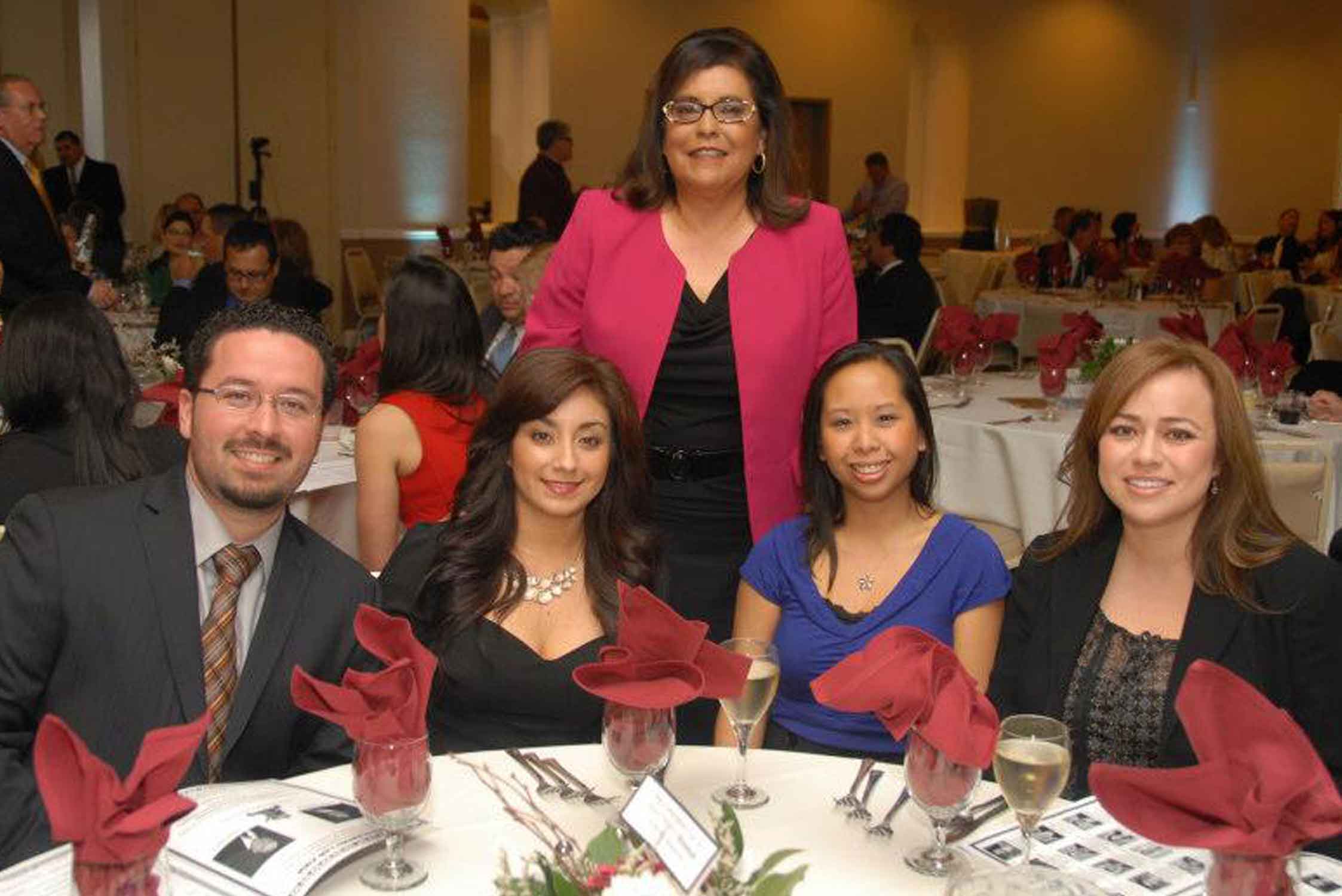 Members of La Raza Law sitting at a table at an event.